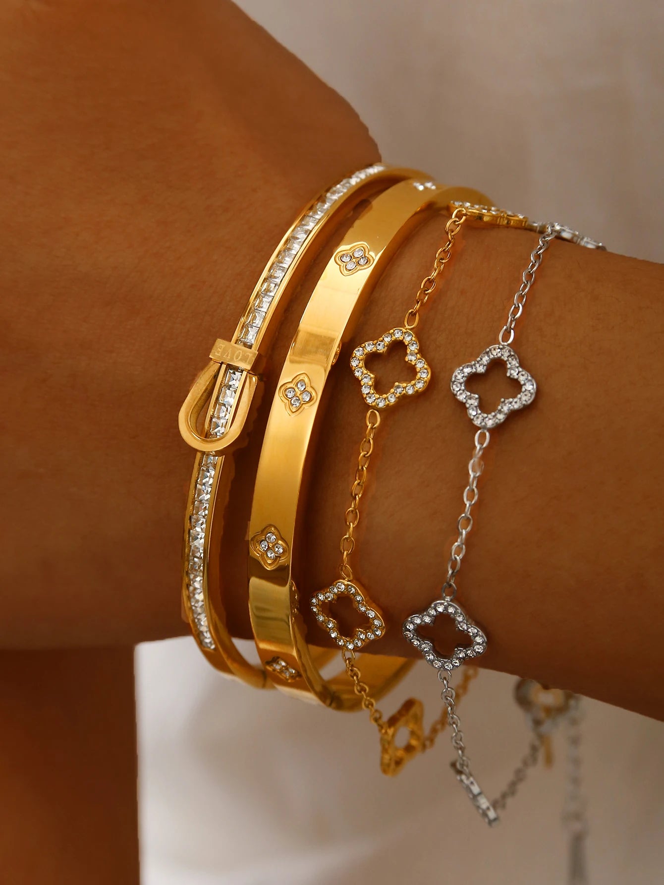 Luxury Clover Bracelet for Women mit goldenen und silbernen Bangles, elegant am Handgelenk präsentiert.